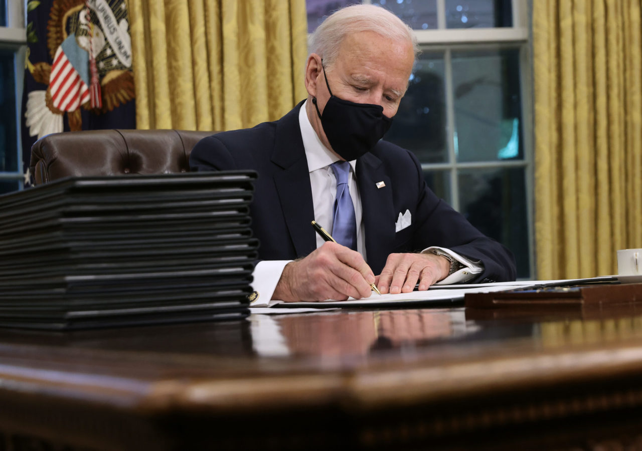 Photo of President Joe Biden signing a series of executive orders